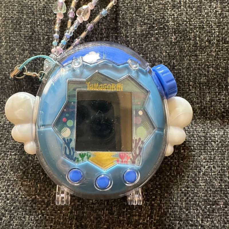 Bandai Model Tamagotchi - ใหม่ในสต็อก! เคสป้องกันแทมาก็อตจิ ปีกกลิตเตอร์ รุ่นแองเจิลเดวิล สีดำและสีขาว รุ่นพาราไดซ์แฮปปี้พาร์ค